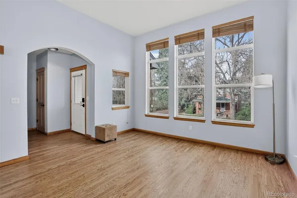 a view of an empty room with window and wooden floor