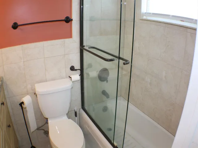 a white toilet sitting next to a shower