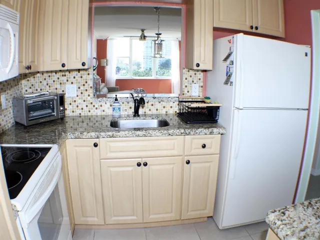 a kitchen with stainless steel appliances white cabinets and a refrigerator