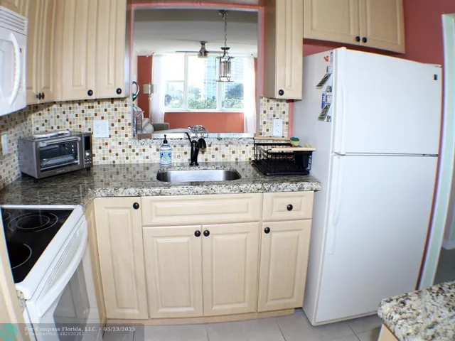 a kitchen with stainless steel appliances white cabinets and a refrigerator