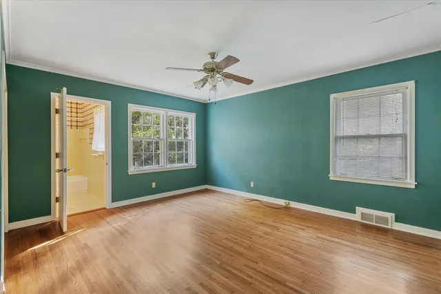 an empty room with ceiling fan and window
