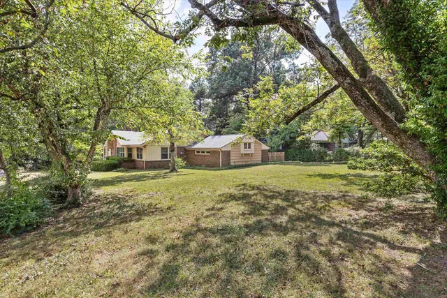 a backyard of a house with table and chairs