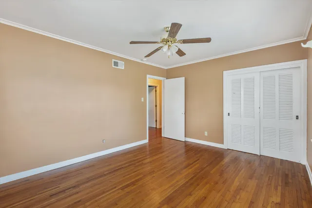 a view of an empty room with wooden floor