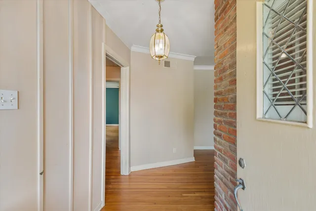 a view of a hallway with wooden floor and staircase