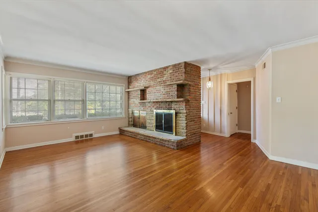 an empty room with wooden floor and fireplace