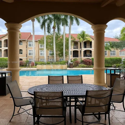 a patio with a table and chairs and potted plants