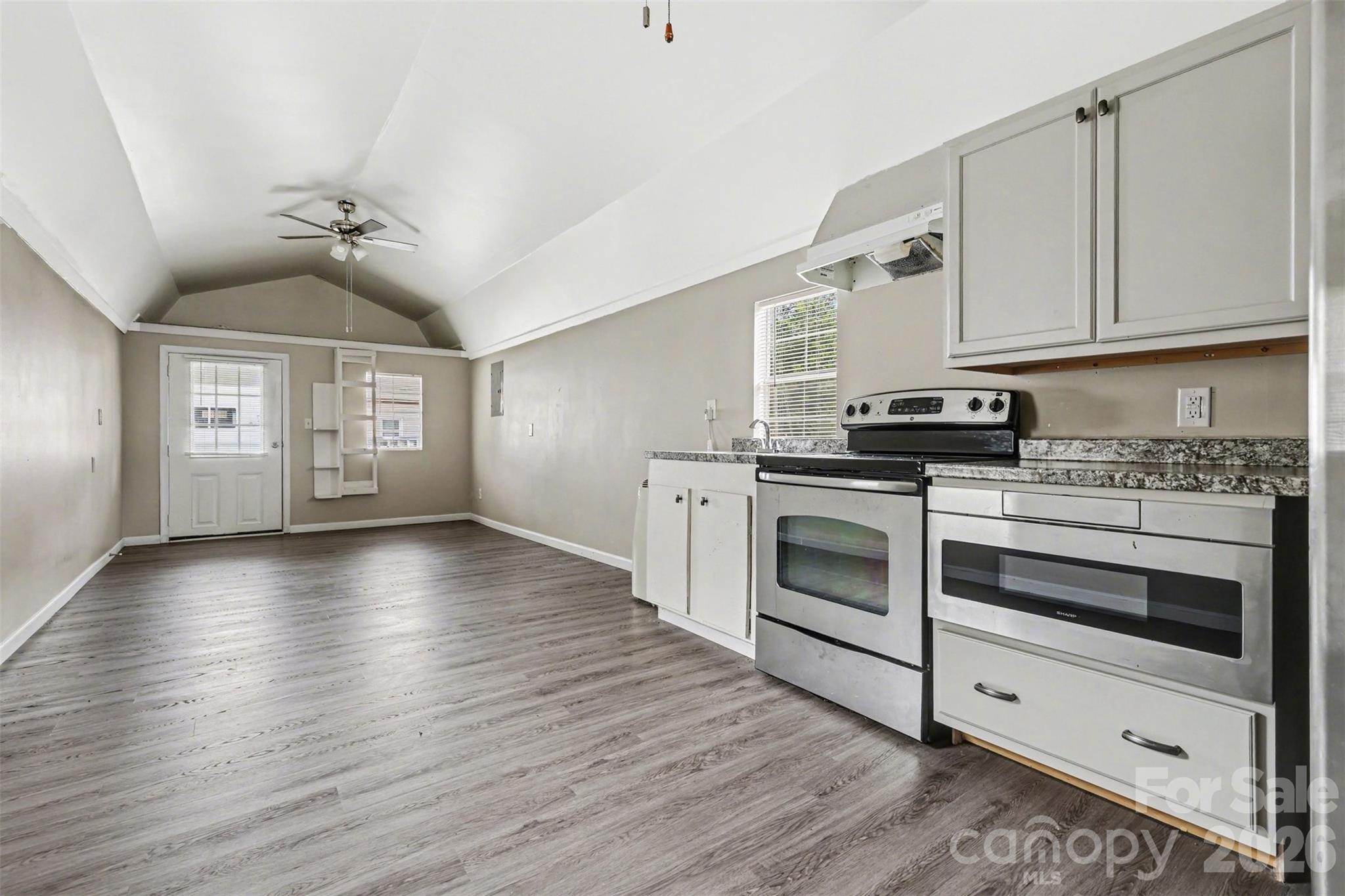 596 Armory Road Chester, SC 29706 - Photo 10 of 25 a kitchen with stainless steel appliances granite countertop a stove a sink and white cabinets with wooden floors