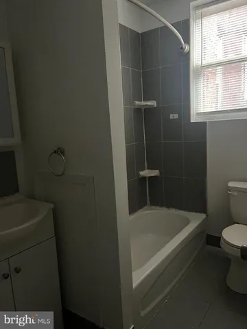 a white bath tub sitting next to a toilet