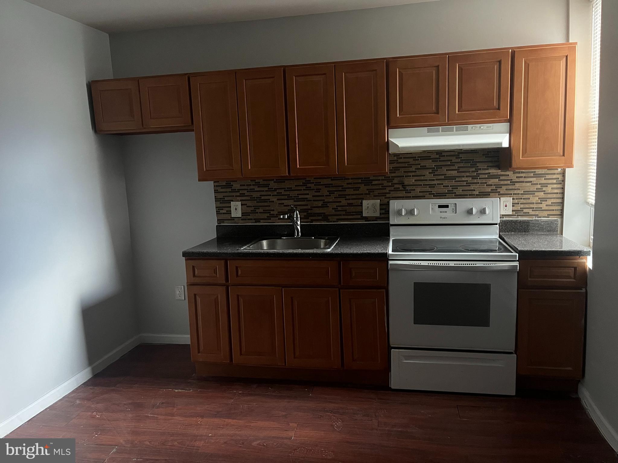 6122 North Broad Street Philadelphia, PA 19141 - Photo 8 of 18 a kitchen with wooden cabinets and a stove top oven