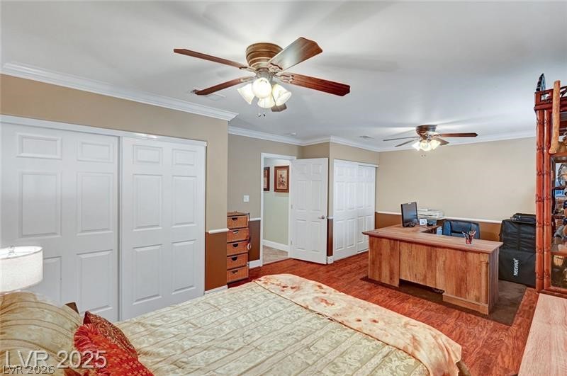 2410 Doherty Way Henderson, NV 89014 - Photo 38 of 63 Bedroom featuring wood finished floors, multiple closets, a desk, ornamental molding, and ceiling fan