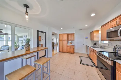 a kitchen with stainless steel appliances granite countertop a sink counter space cabinets and a dining table