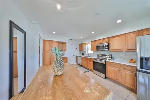 a large white kitchen with stainless steel appliances granite countertop lots of counter top space