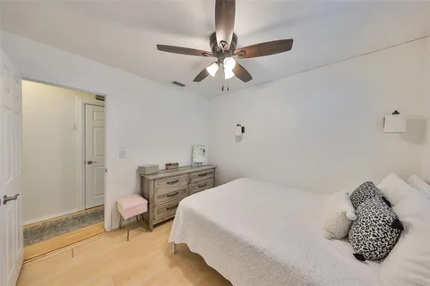 a bedroom with a bed and a chandelier fan