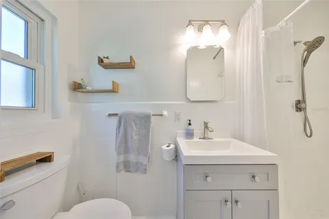 a bathroom with a sink mirror and toilet