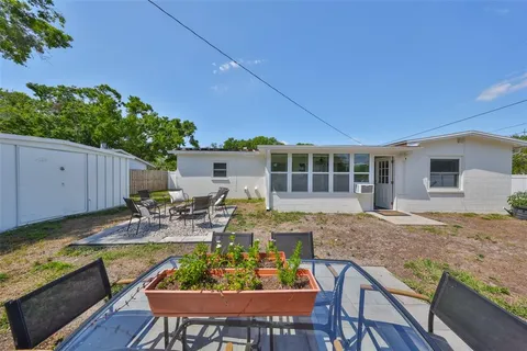 a view of a house with backyard and sitting area