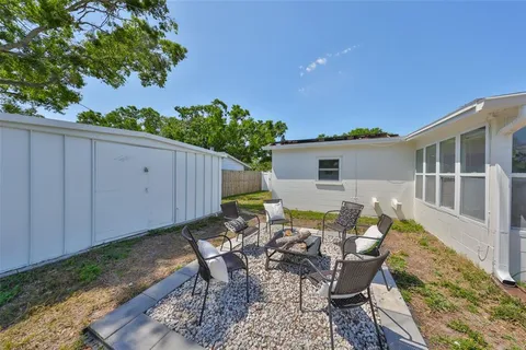 a view of a house with backyard and sitting area