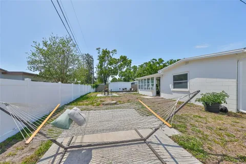 a view of backyard with wheel chair potted plants and large tree