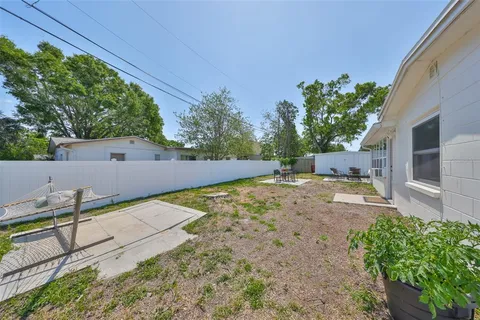 a view of a backyard with potted plants and large tree