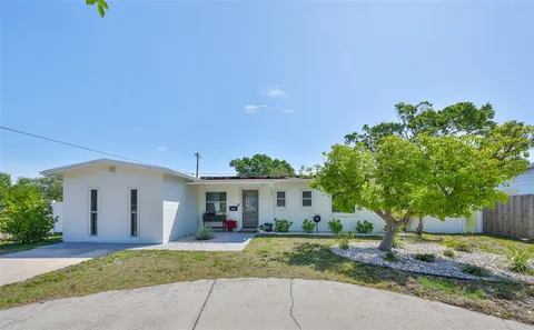a view of a house with a yard and large tree