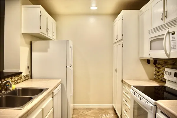 a kitchen with stainless steel appliances granite countertop a sink and a refrigerator