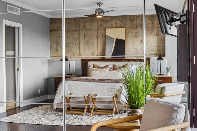 a bedroom with a bed and potted plant with view of bathroom
