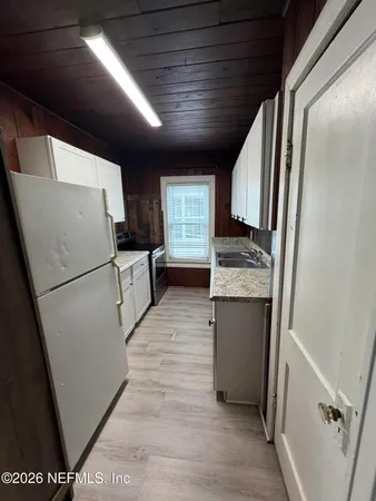 a kitchen with refrigerator and cabinets
