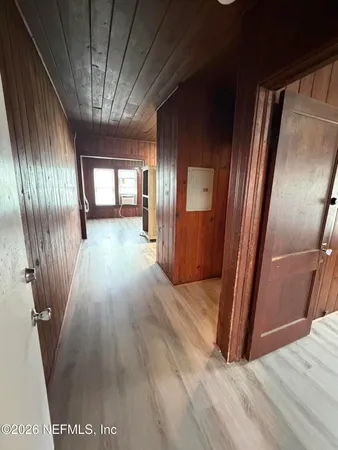 a view of a hallway with wooden floor