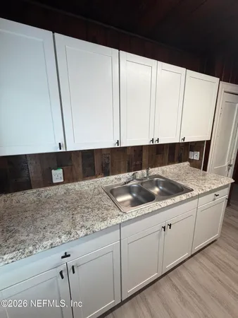 a kitchen with granite countertop sink and cabinets