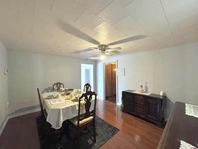 a view of a dining room with furniture and a chandelier fan