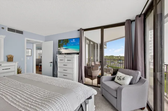 a bedroom with a bed couch and a flat tv screen