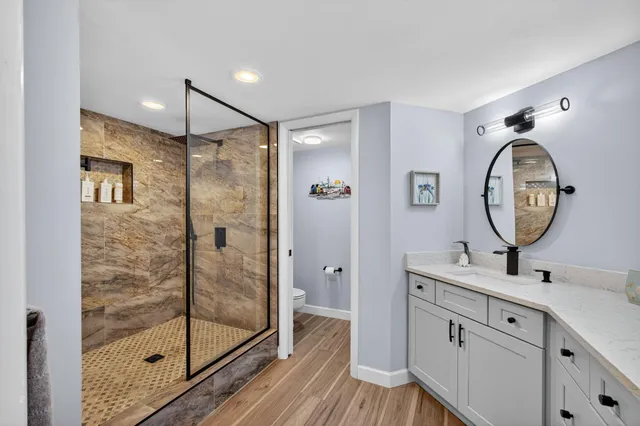 a bathroom with a double vanity sink mirror and shower
