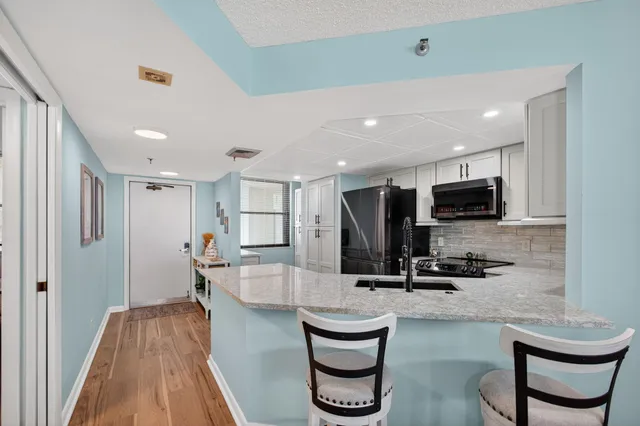 a kitchen with sink microwave and refrigerator