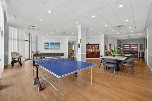 a living room with furniture a wooden floor and potted plants
