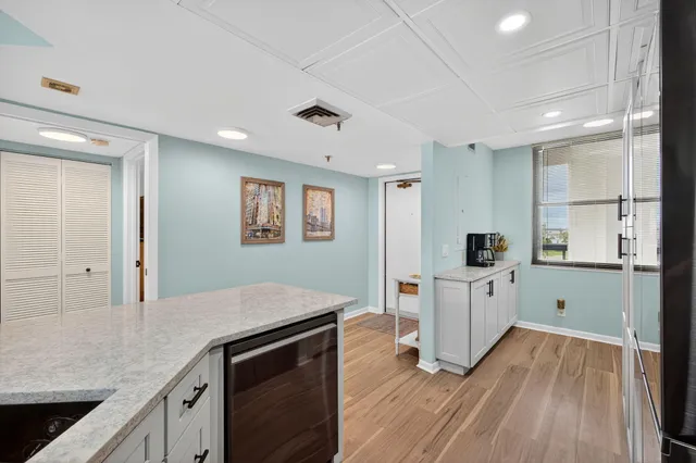 a kitchen with white cabinets and sink