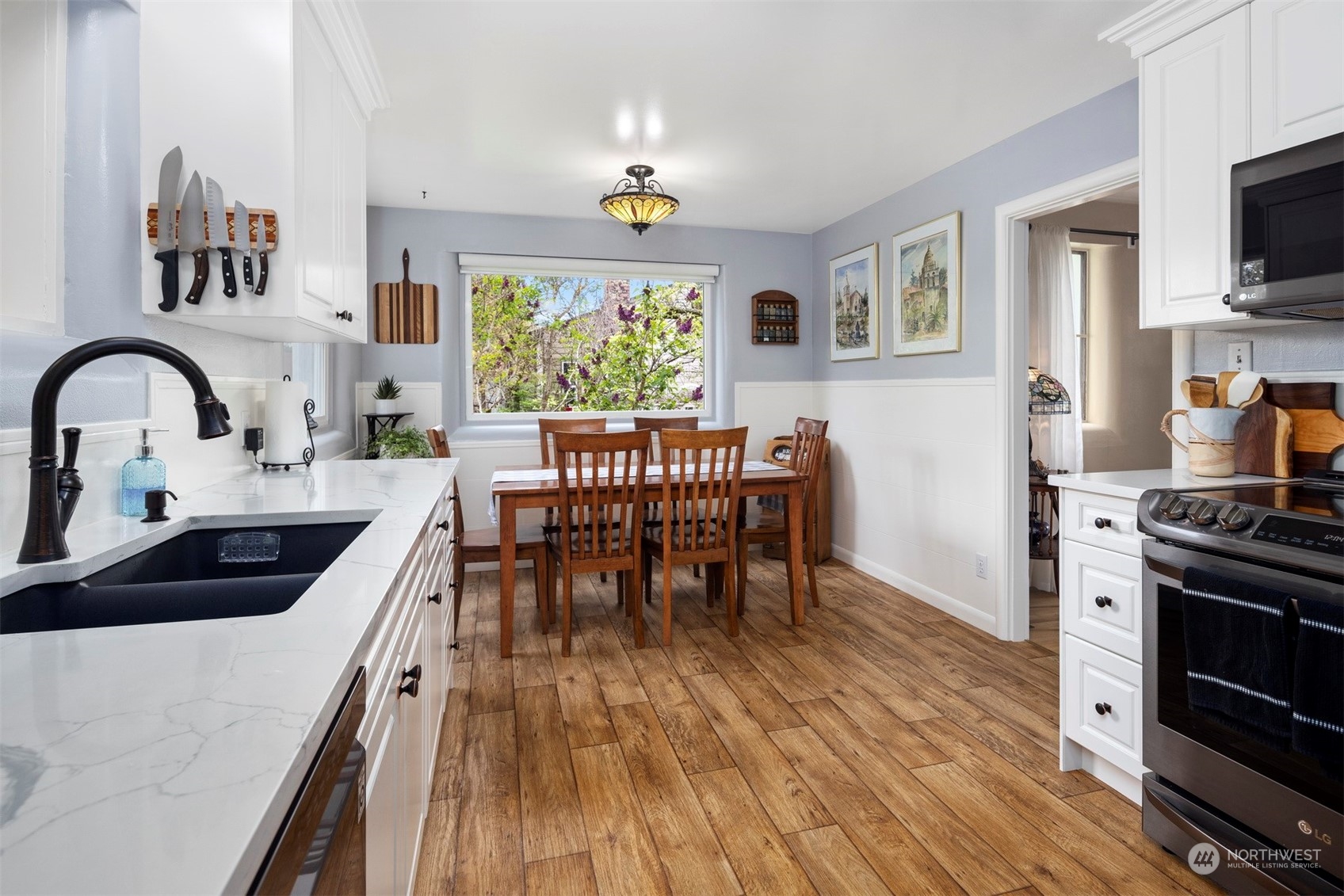 2931 McLeod Road Bellingham, WA 98225 - Photo 9 of 37 a kitchen with stainless steel appliances a dining table chairs a stove top oven with wooden floor