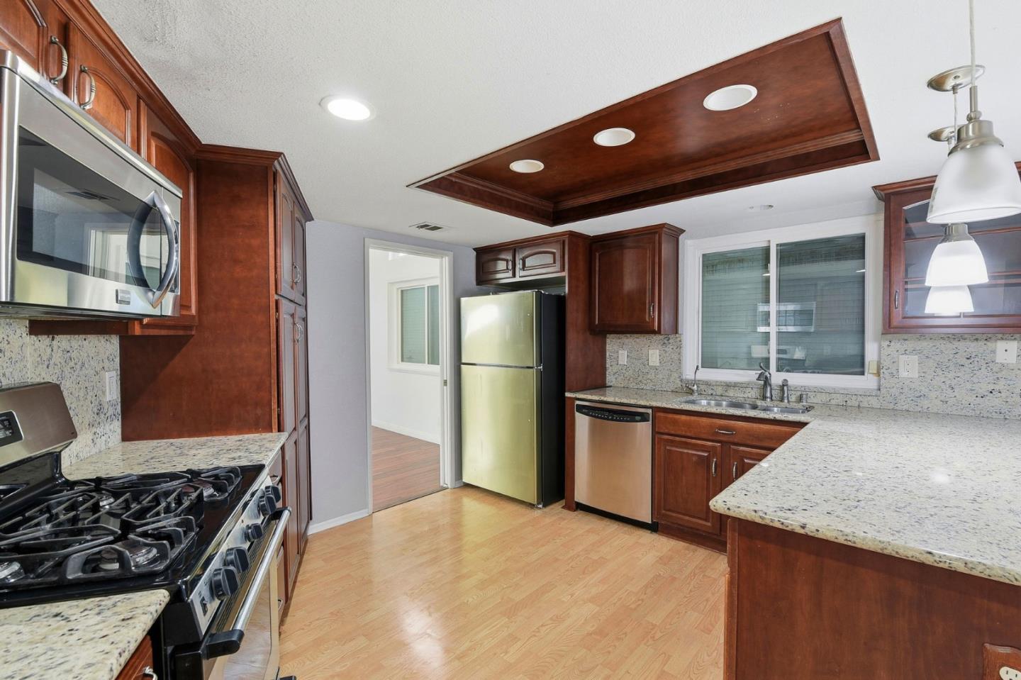 44648 17th Street East Lancaster, CA 93535 - Photo 5 of 21 a kitchen with stainless steel appliances granite countertop a refrigerator a stove and a sink with wooden floor