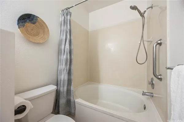 a bathroom with a granite countertop bathtub shower and toilet