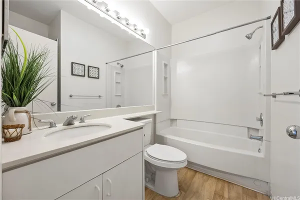 a bathroom with a granite countertop sink a toilet and shower
