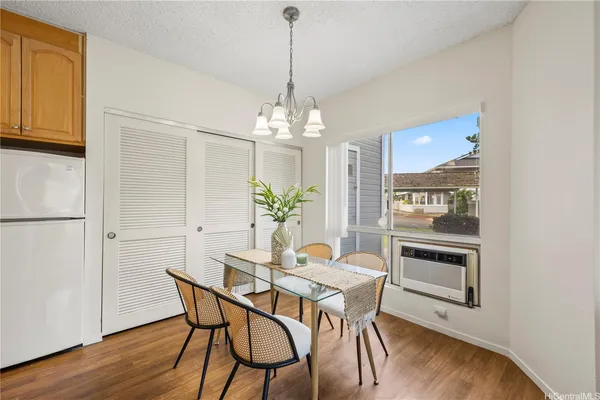 a dining room with furniture potted plants and wooden floor