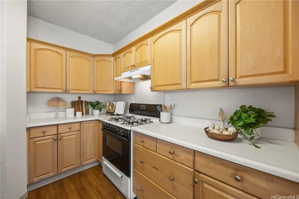 a kitchen with stainless steel appliances granite countertop white cabinets sink and stove