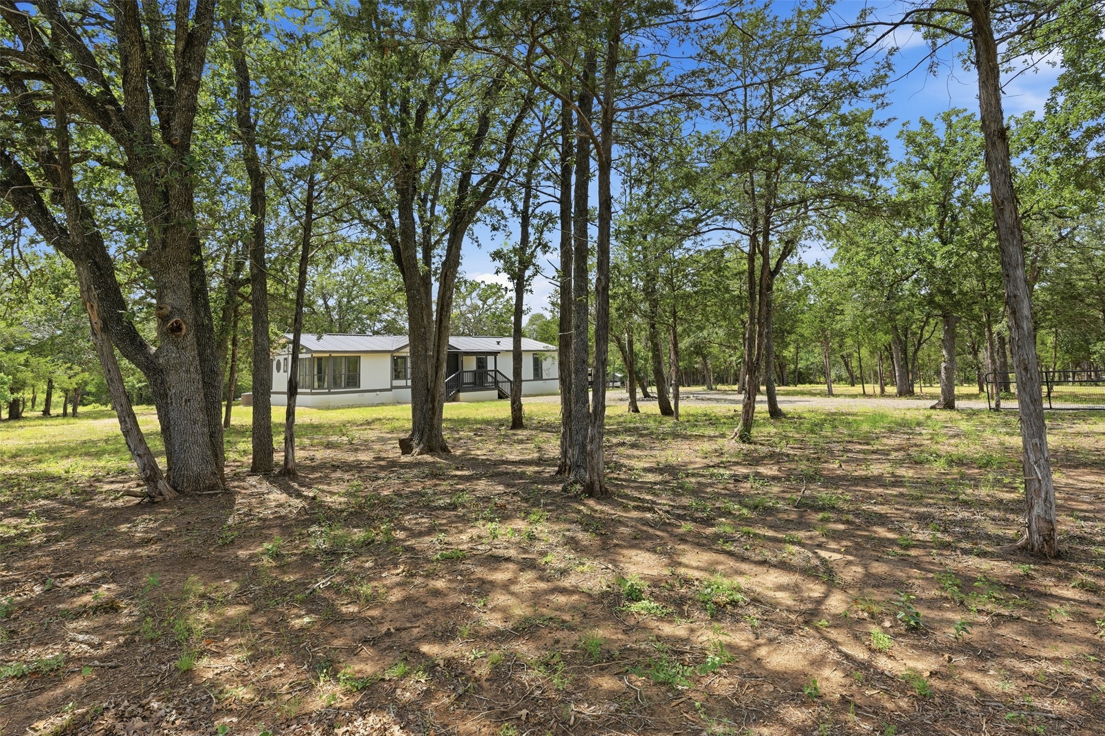 154 Antioch Road Smithville, TX 78957 - Photo 1 of 32 Mature trees shade a peaceful residence nestled in a verdant, sprawling setting.