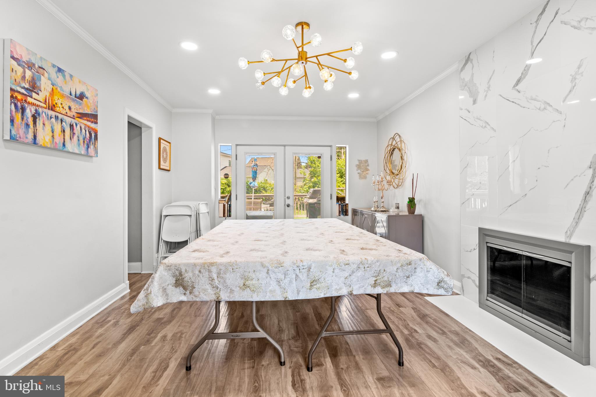 3302 Northbrook Road Baltimore, MD 21208 - Photo 12 of 35 a open kitchen with stainless steel appliances granite countertop a stove top oven a chimney and a dining table with wooden floor
