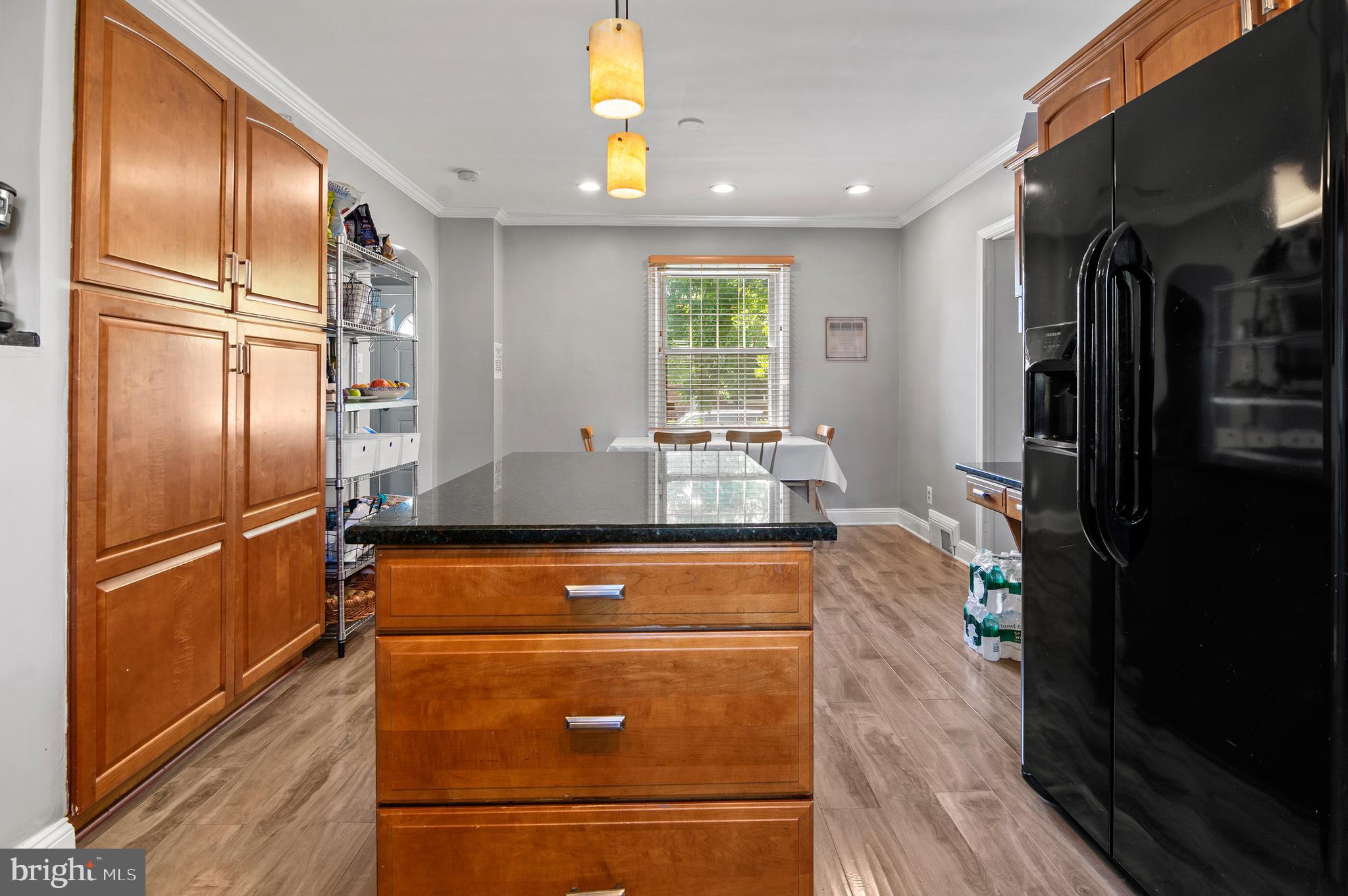 3302 Northbrook Road Baltimore, MD 21208 - Photo 7 of 35 a kitchen with kitchen island a counter top space and stainless steel appliances wooden floor