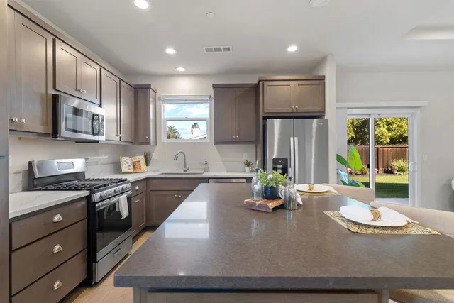 a large kitchen with kitchen island granite countertop a large window
