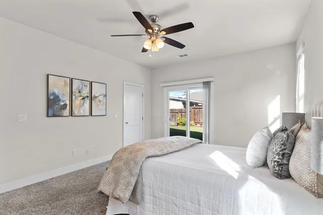 a bedroom with a large bed and a ceiling fan