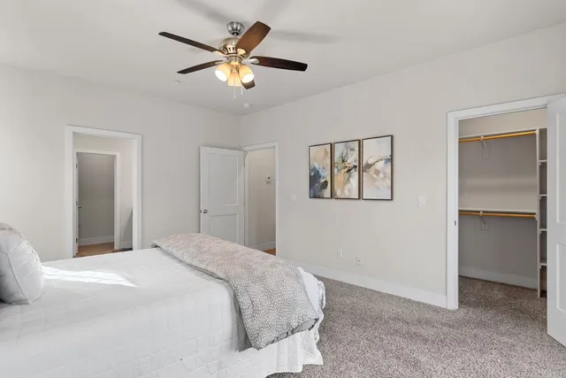 a bedroom with a large bed and a ceiling fan