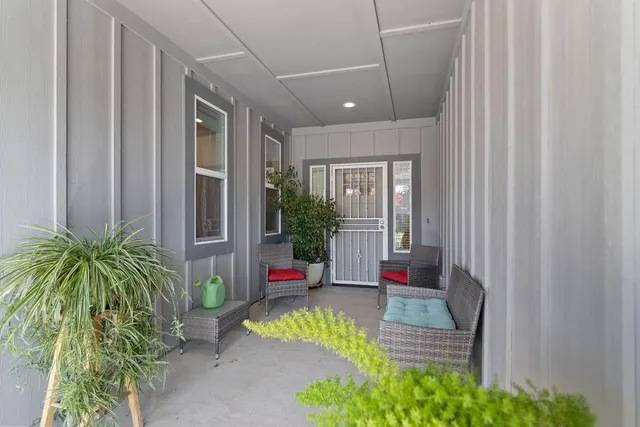 a porch with a table and chairs next to a window