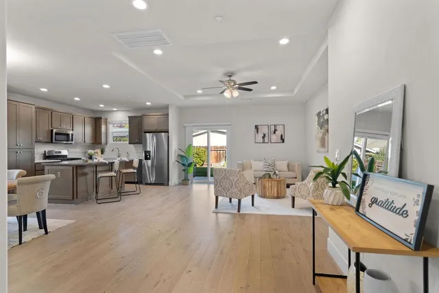 a living room with lots of furniture kitchen view and a dining table