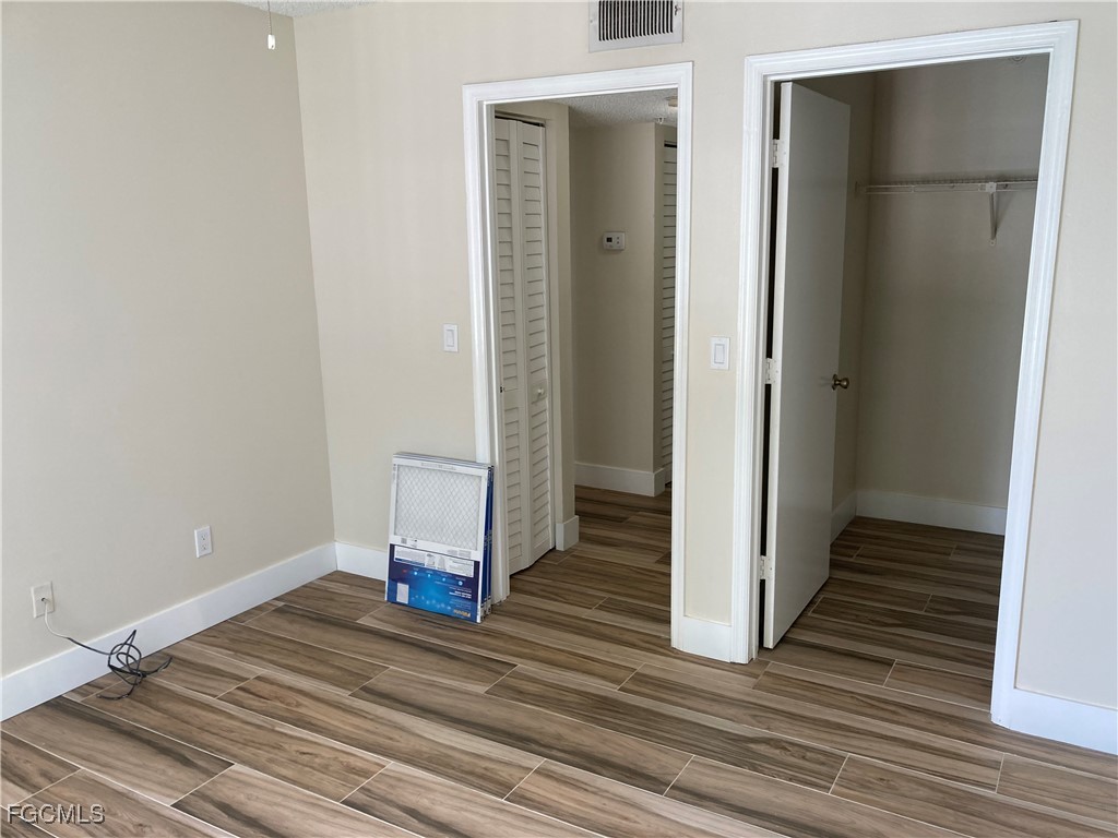 13521 Eagle Ridge Drive, Unit 128 Fort Myers, FL 33912 - Photo 8 of 11 a view of a room with wooden floor and a ceiling fan
