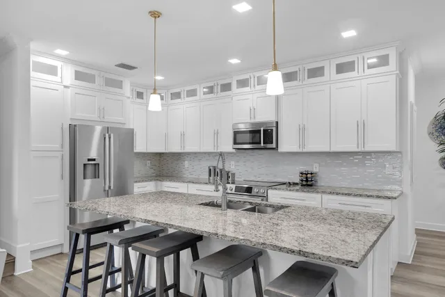 a kitchen with granite countertop kitchen island a stove a table and chairs in it